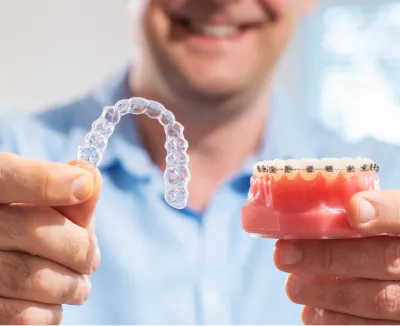 Image of clear aligners and a modal of teeth with braces