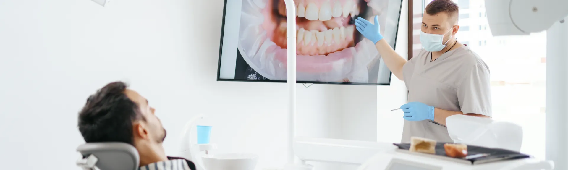 Dentist talking to patient in exam room